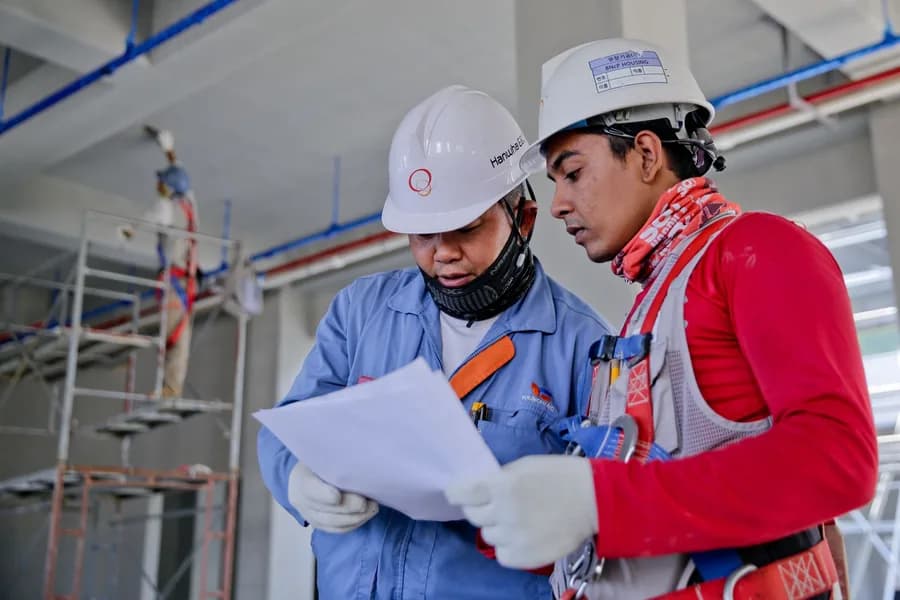 Two engineers reviewing drawings on site